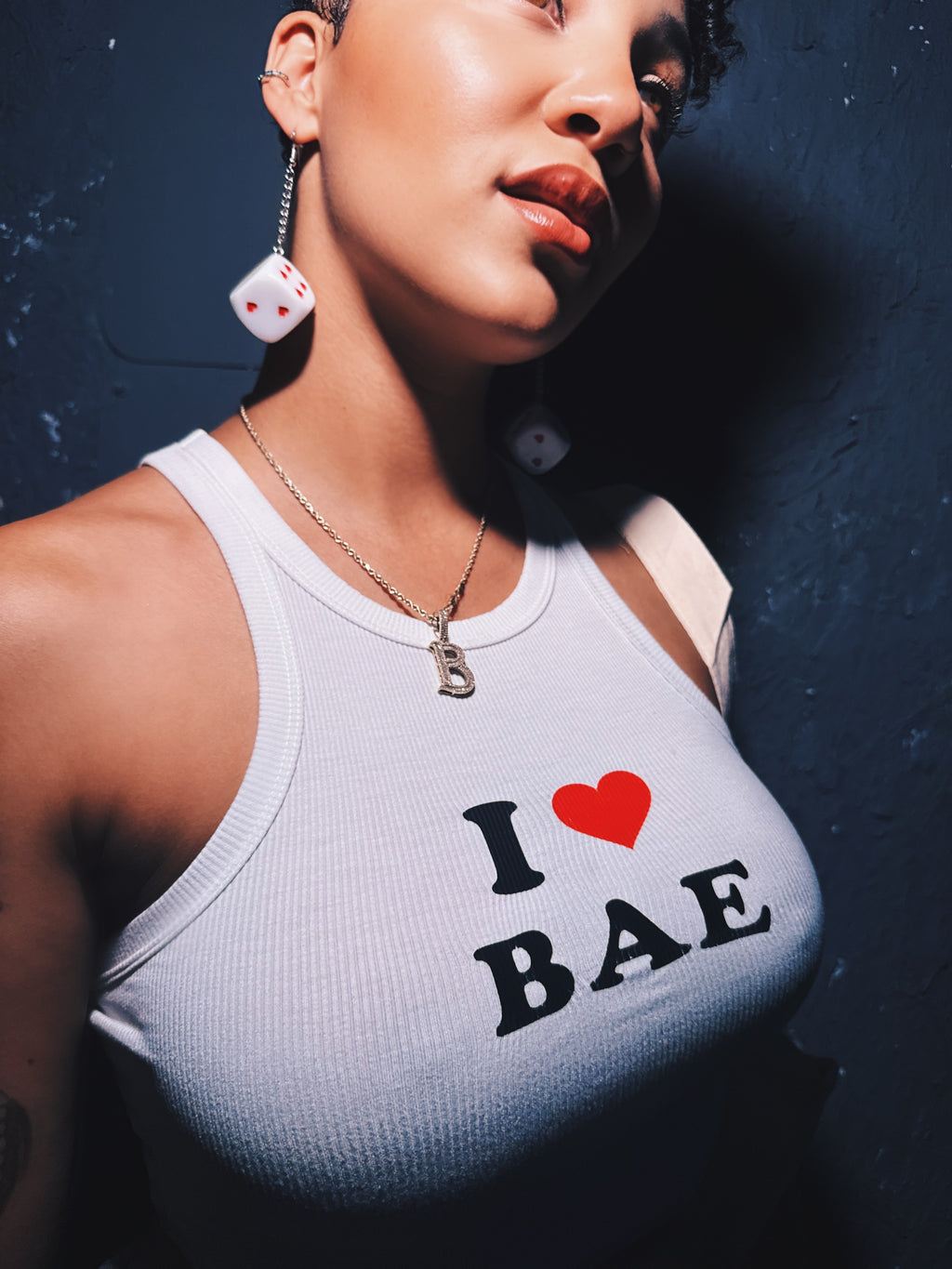 Baely wearing a tank top with 'I ❤️ BAE' text against a dark background
